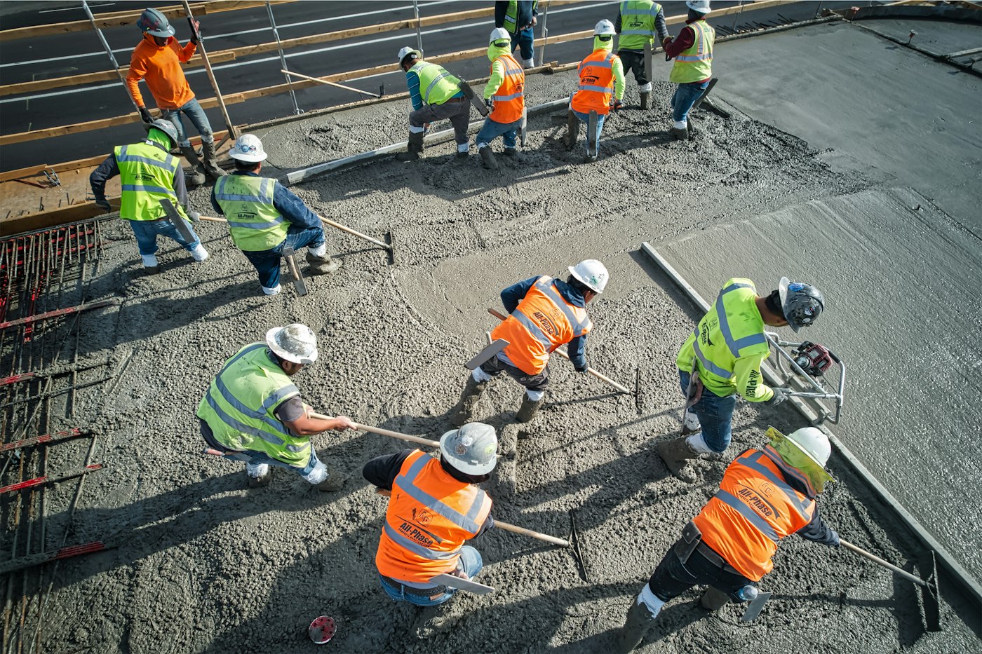 Equipe de capacete e colete na concretagem da laje
