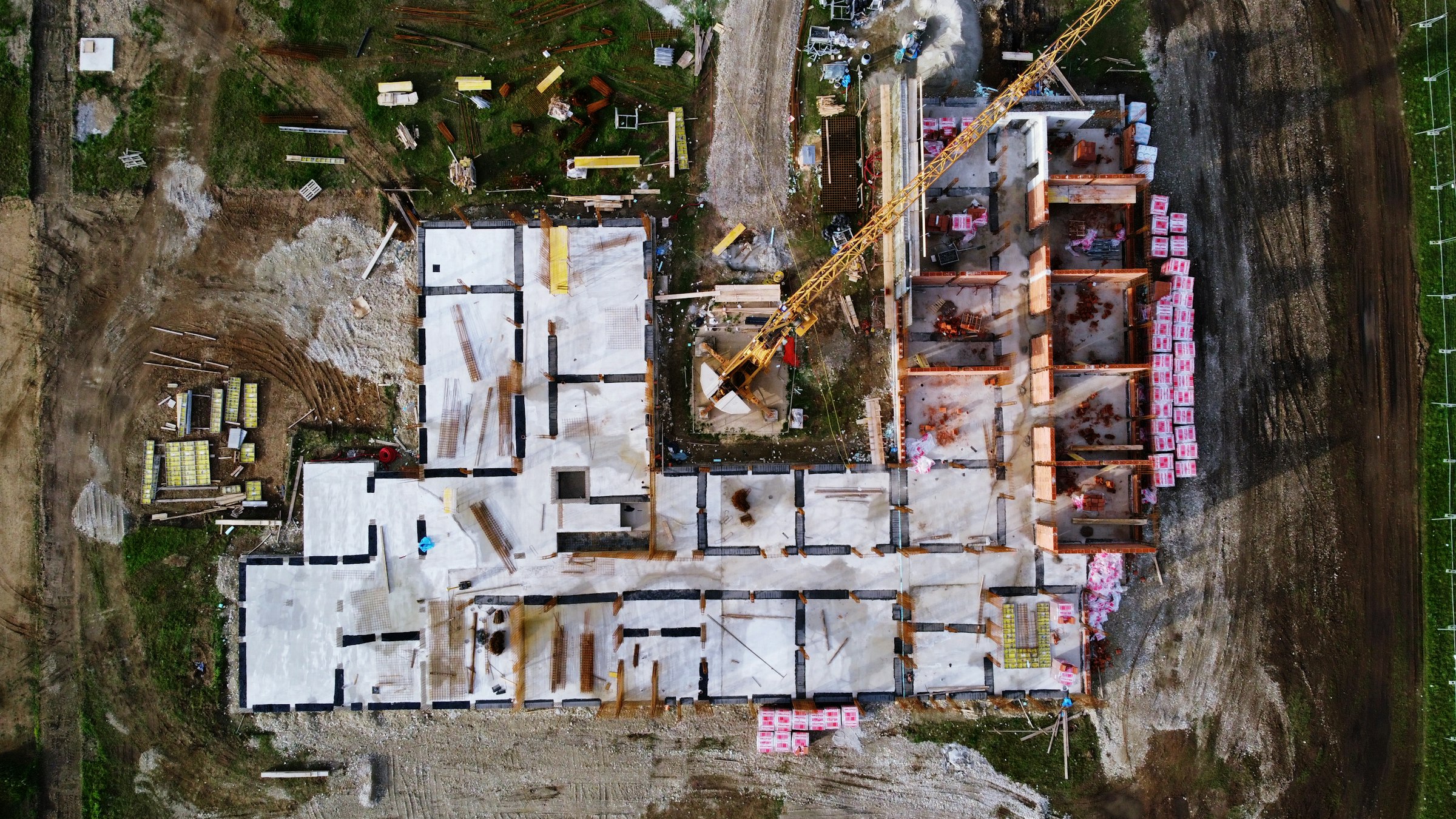 Vista aérea de uma estrutura de concreto em construção com grua de torre